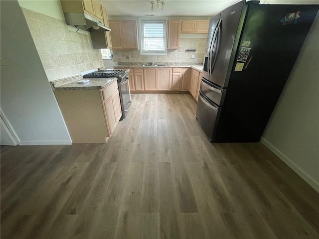 kitchen with stainless steel appliances, tasteful backsplash, light wood-style floors, light brown cabinets, and baseboards