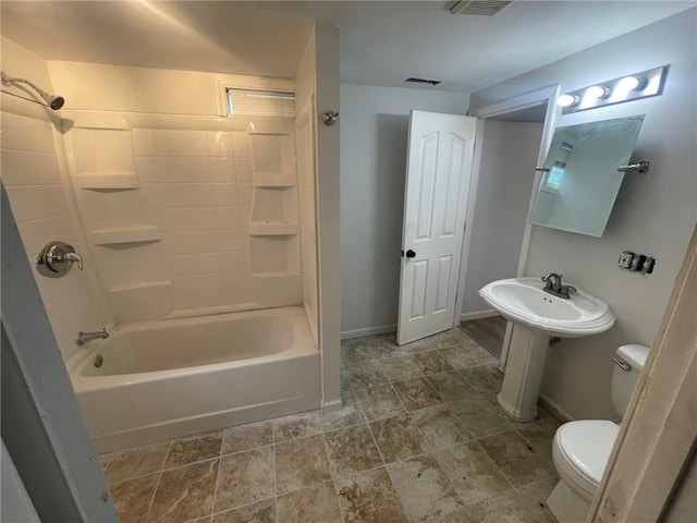 bathroom featuring toilet, visible vents, baseboards, and shower / bathing tub combination