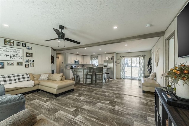 living area with a textured ceiling, ceiling fan, recessed lighting, dark wood-style flooring, and beam ceiling