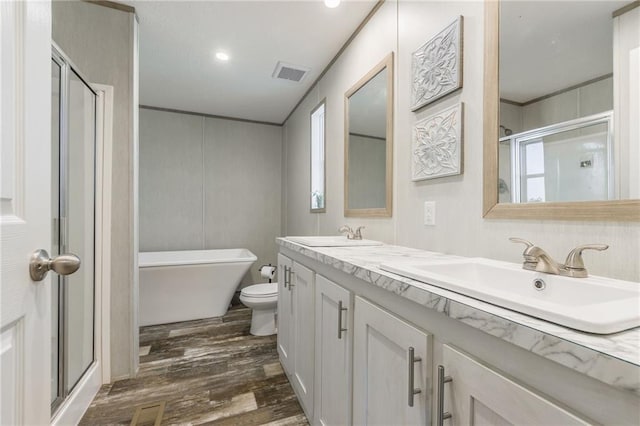 full bath featuring a stall shower, visible vents, a sink, and wood finished floors