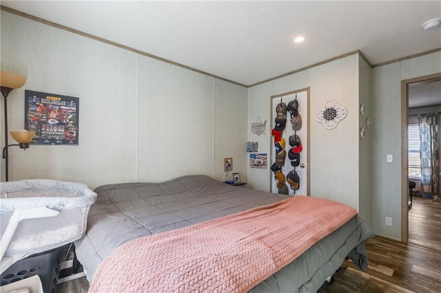 bedroom with crown molding and wood finished floors