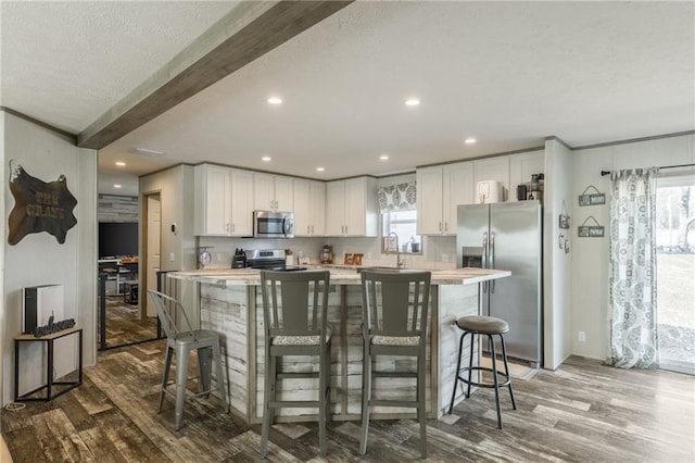 kitchen featuring light countertops, appliances with stainless steel finishes, and wood finished floors