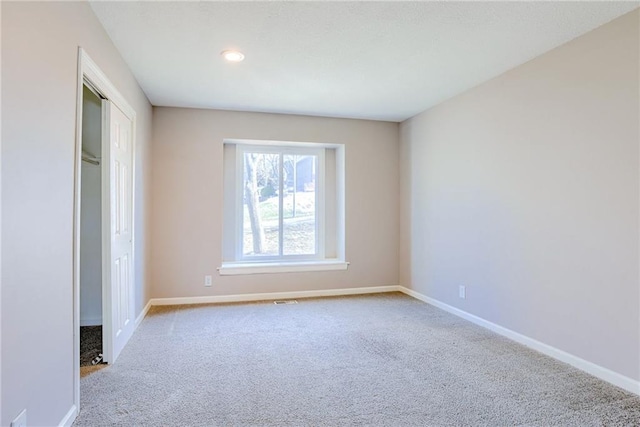 unfurnished bedroom featuring carpet floors, baseboards, and a closet