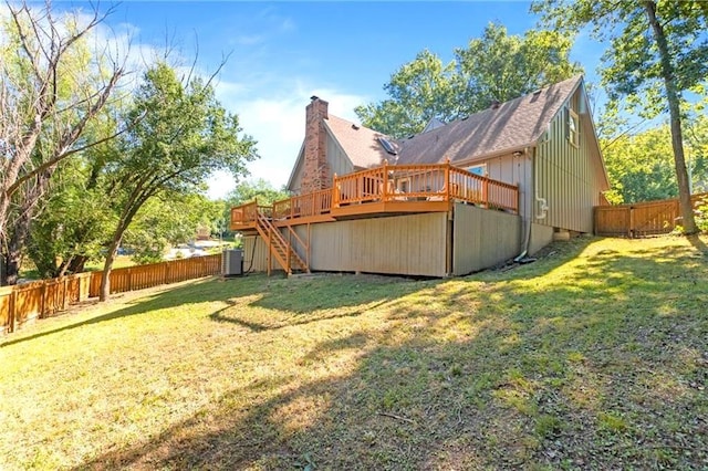 back of house featuring a deck, a fenced backyard, a chimney, and stairs