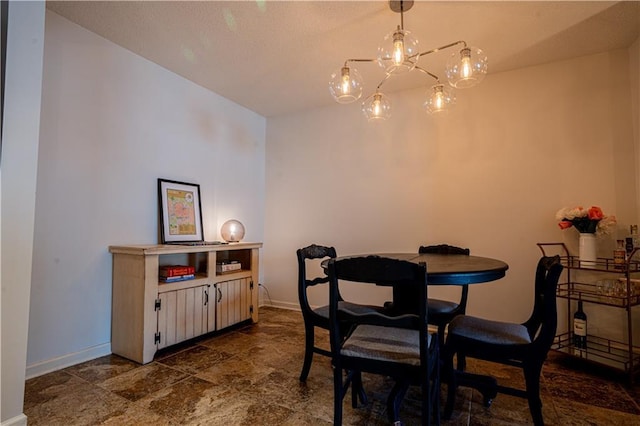 dining space featuring an inviting chandelier and baseboards