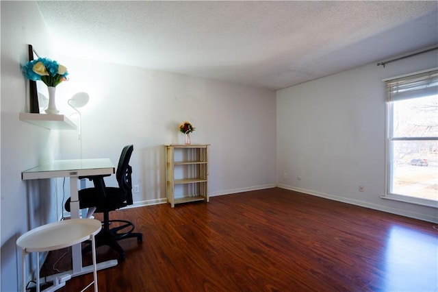 office area featuring a textured ceiling, baseboards, and wood finished floors