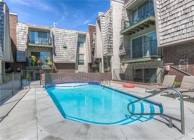 community pool featuring a patio and fence