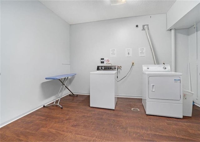 community laundry room featuring baseboards, washing machine and clothes dryer, and wood finished floors