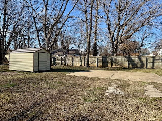 view of yard featuring an outbuilding, a storage unit, and fence