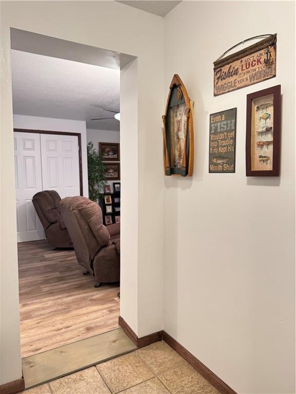 hall featuring light wood-style floors and baseboards