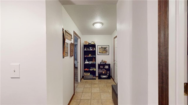 hall with a textured ceiling and baseboards