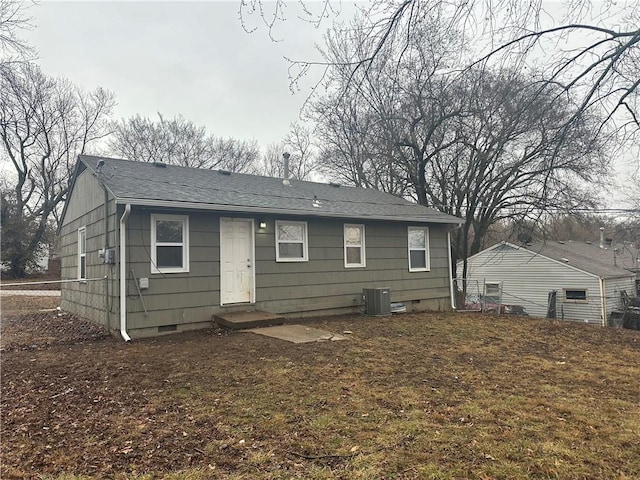 rear view of house with roof with shingles, crawl space, and cooling unit