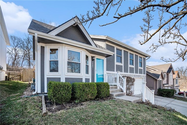 view of front of property featuring a front lawn, fence, concrete driveway, stucco siding, and an attached garage