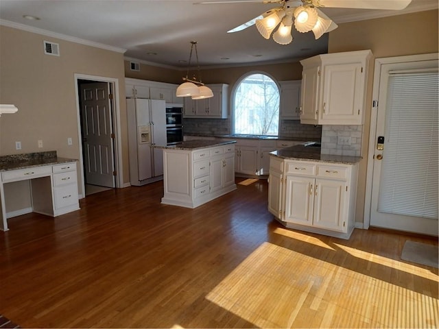 kitchen with dark wood-style floors, white fridge with ice dispenser, visible vents, and white cabinets