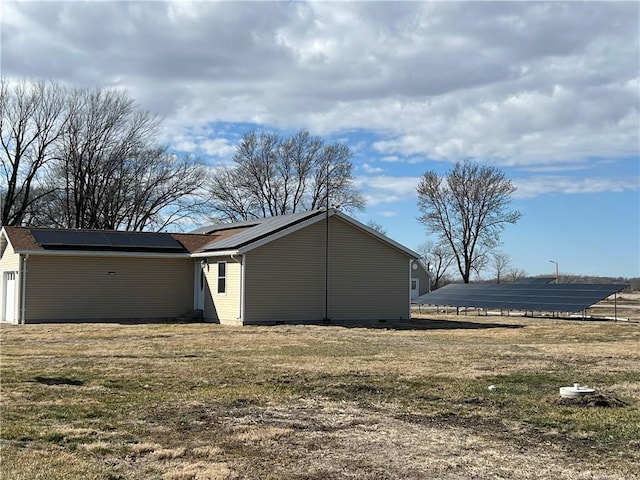 view of side of property with crawl space and solar panels