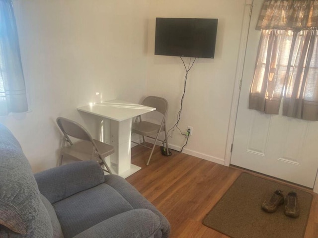 living area with baseboards and wood finished floors