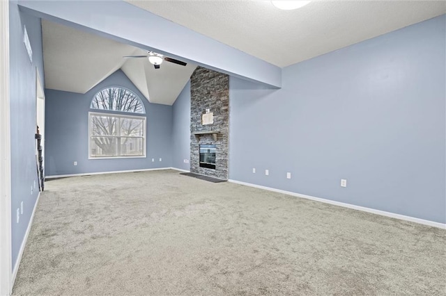 unfurnished living room with baseboards, lofted ceiling, ceiling fan, carpet flooring, and a fireplace