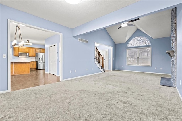 unfurnished living room with stairs, carpet, visible vents, vaulted ceiling, and ceiling fan with notable chandelier