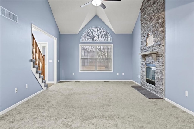 unfurnished living room featuring baseboards, ceiling fan, stairs, carpet flooring, and a stone fireplace