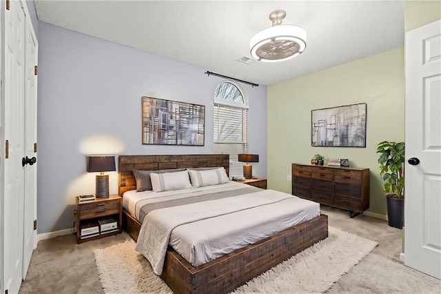 bedroom featuring baseboards, visible vents, and light colored carpet