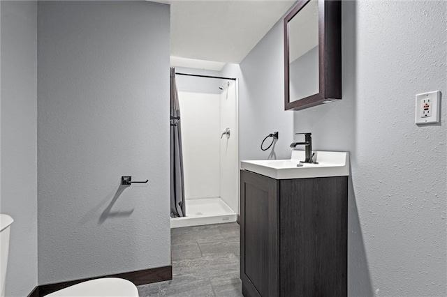 bathroom featuring vanity, toilet, and a shower stall