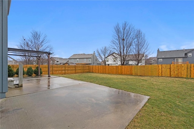 view of yard featuring a residential view, a patio area, and a fenced backyard