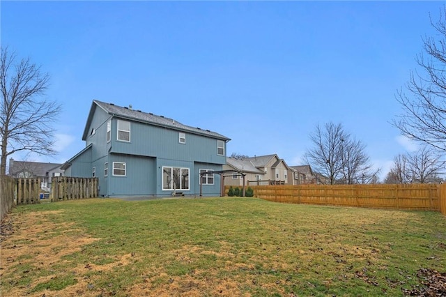 back of house featuring a fenced backyard and a yard