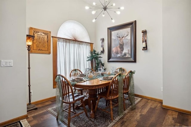 dining space with baseboards, an inviting chandelier, and wood finished floors