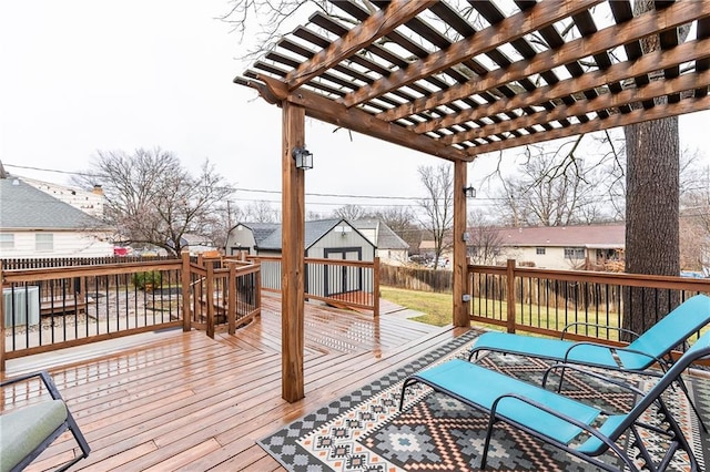 wooden deck featuring an outbuilding, a residential view, a pergola, and fence