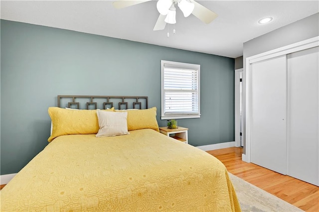 bedroom featuring baseboards, wood finished floors, a closet, and ceiling fan