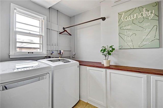 laundry area with washer and clothes dryer, light tile patterned floors, and cabinet space