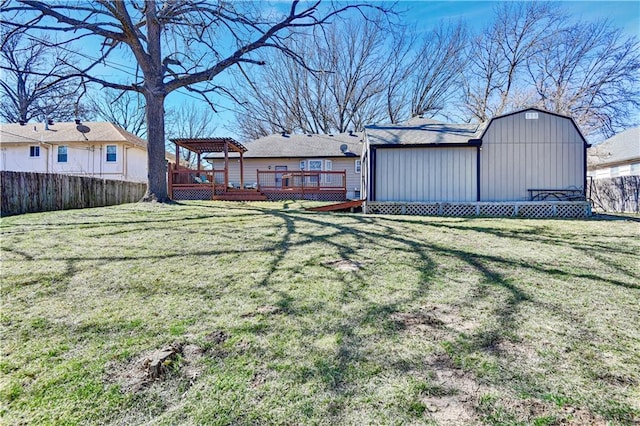 view of yard featuring a deck, an outbuilding, and fence