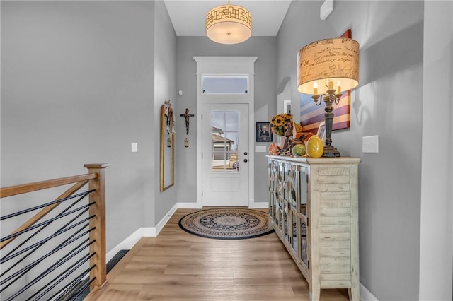 entryway with baseboards and wood finished floors