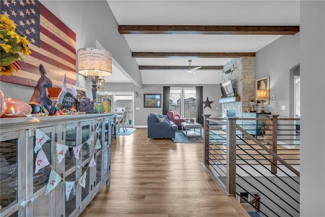 corridor featuring a notable chandelier, wood finished floors, an upstairs landing, baseboards, and beamed ceiling