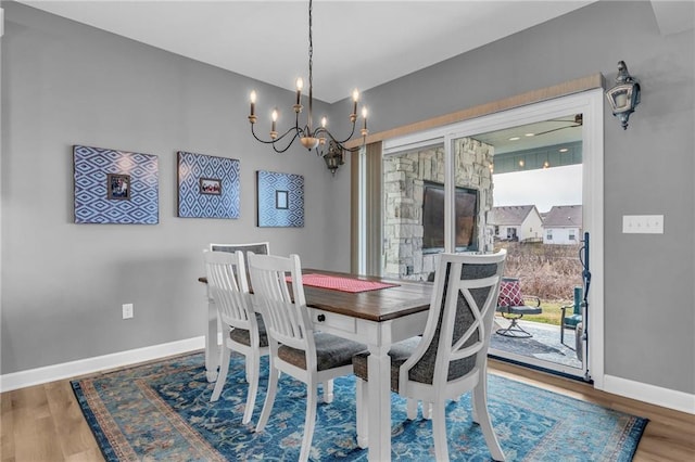 dining room featuring an inviting chandelier, baseboards, and wood finished floors