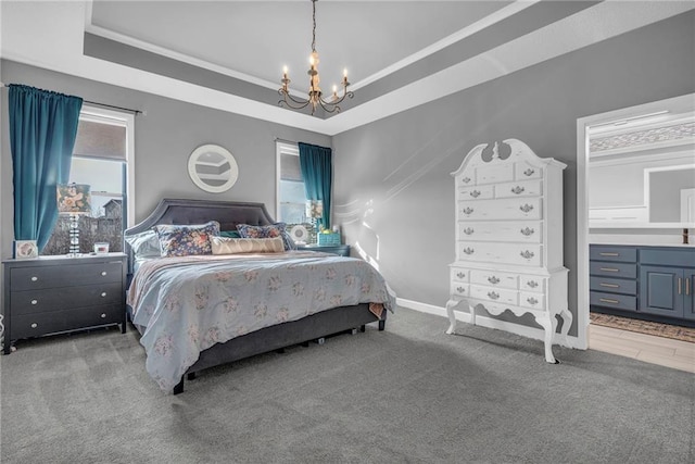 carpeted bedroom with baseboards, a tray ceiling, and a notable chandelier