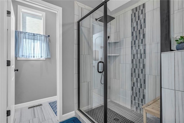 full bathroom with a stall shower, baseboards, and visible vents