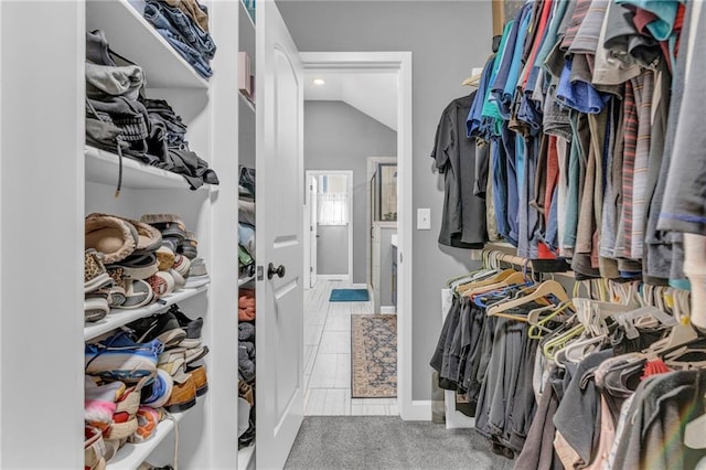 walk in closet with carpet floors and lofted ceiling