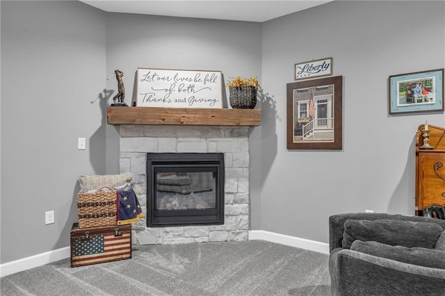 sitting room featuring a stone fireplace, carpet flooring, and baseboards