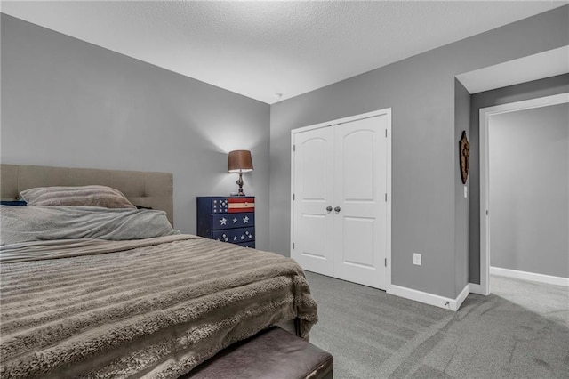 bedroom with carpet, a textured ceiling, baseboards, and a closet