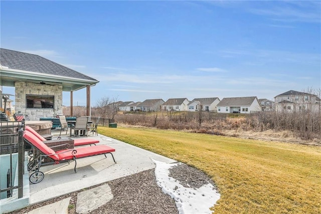 view of yard featuring a patio area, a residential view, and a ceiling fan