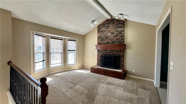 unfurnished living room with vaulted ceiling with beams, baseboards, carpet flooring, a fireplace, and a textured ceiling