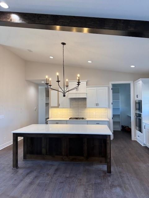 kitchen with appliances with stainless steel finishes, white cabinets, light countertops, and vaulted ceiling with beams