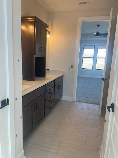 full bathroom featuring double vanity, a sink, a ceiling fan, and baseboards