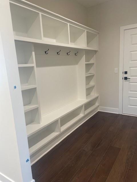 mudroom with dark wood finished floors and baseboards