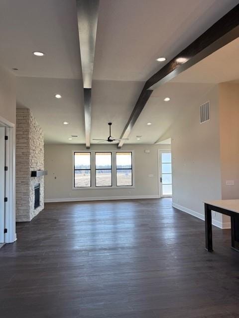 unfurnished living room featuring dark wood-style flooring, visible vents, a fireplace, and baseboards