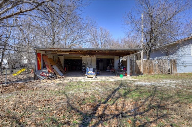 back of house with a garage, an outdoor structure, and an outbuilding