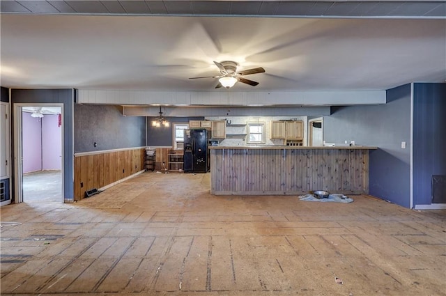 kitchen featuring wainscoting, black refrigerator with ice dispenser, a peninsula, and ceiling fan