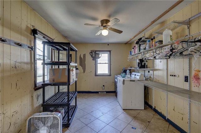 laundry room with light tile patterned floors, a ceiling fan, washer and dryer, laundry area, and baseboards