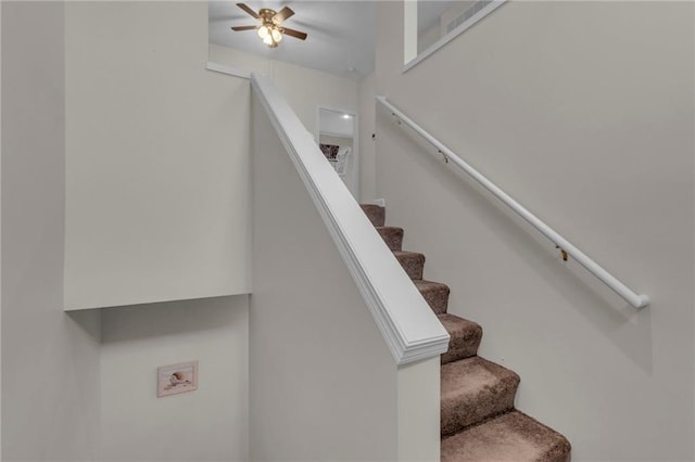 stairway featuring ceiling fan